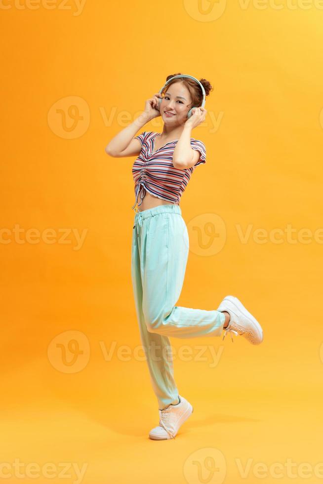 Picture of playful young woman posing over yellow background. Look at camera. photo