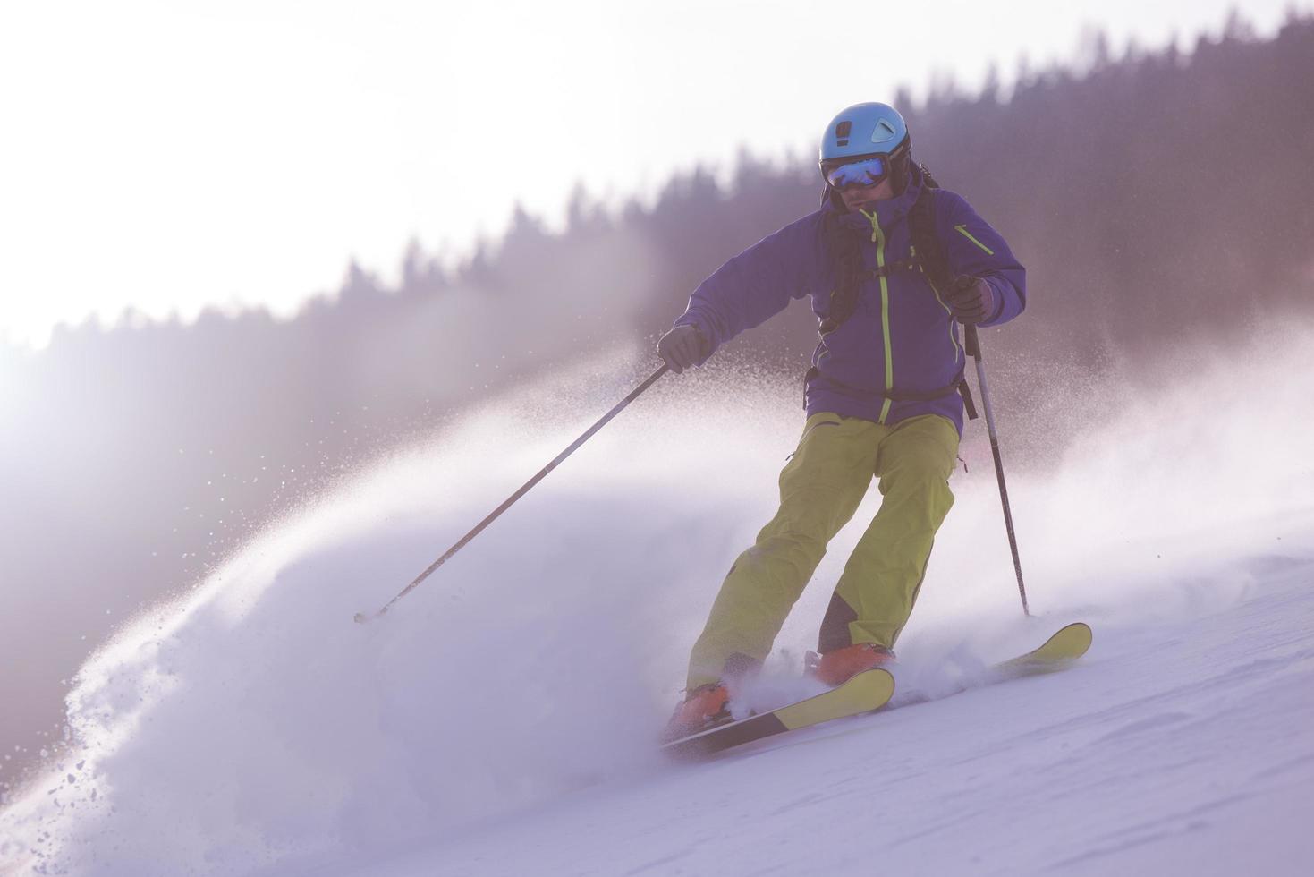 Skier having fun while running downhill photo