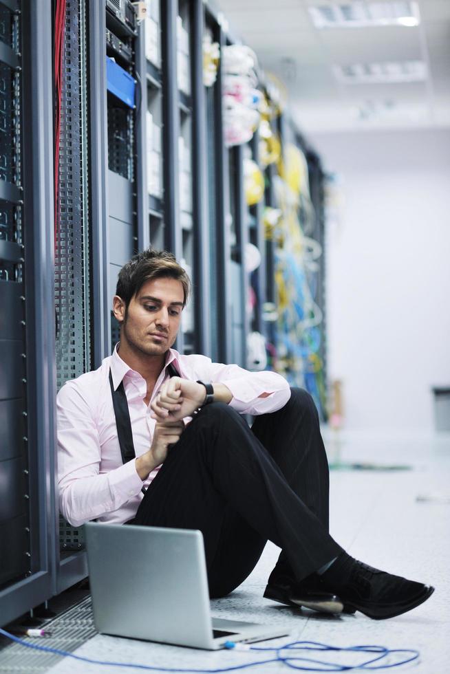 businessman with laptop in network server room photo