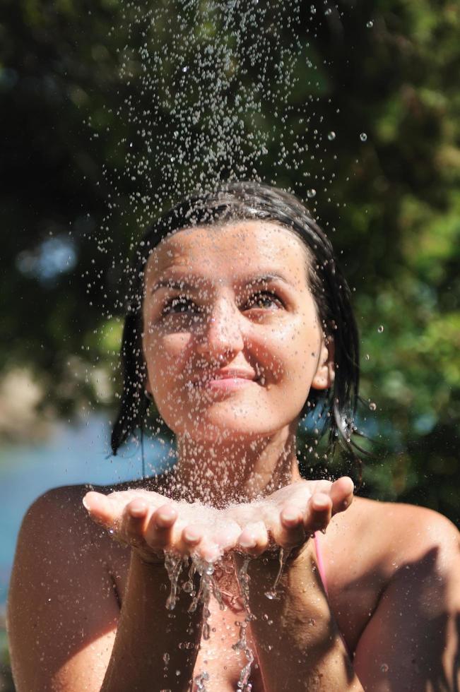 beautiful woman washing and cleaning face under shower photo