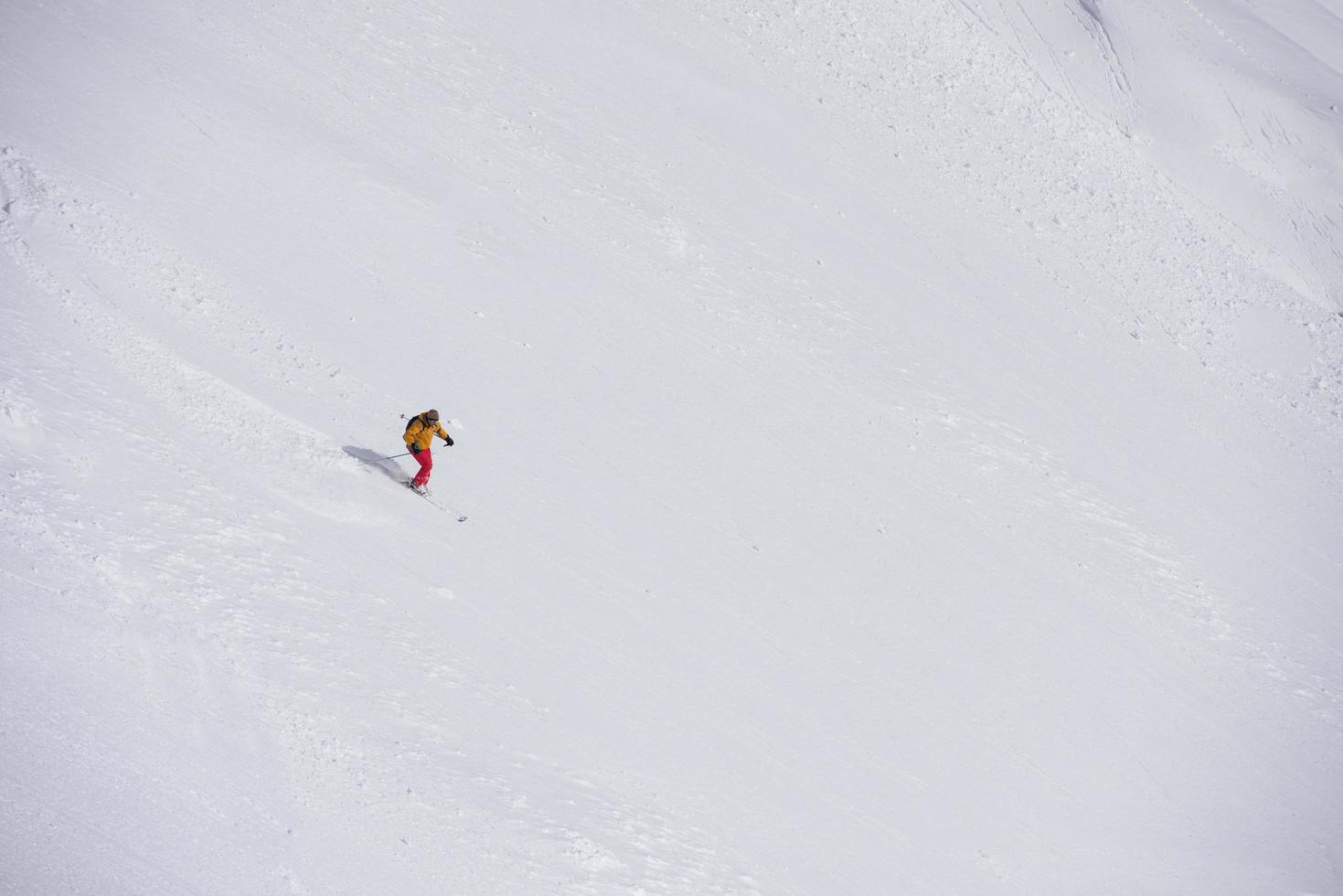 freeride skier skiing in deep powder snow photo