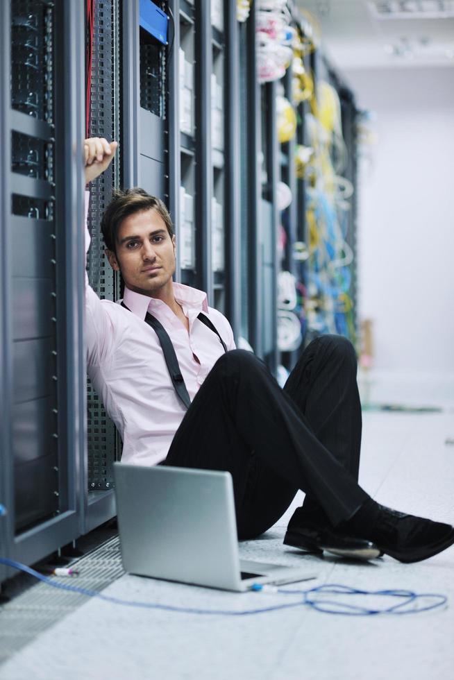 businessman with laptop in network server room photo