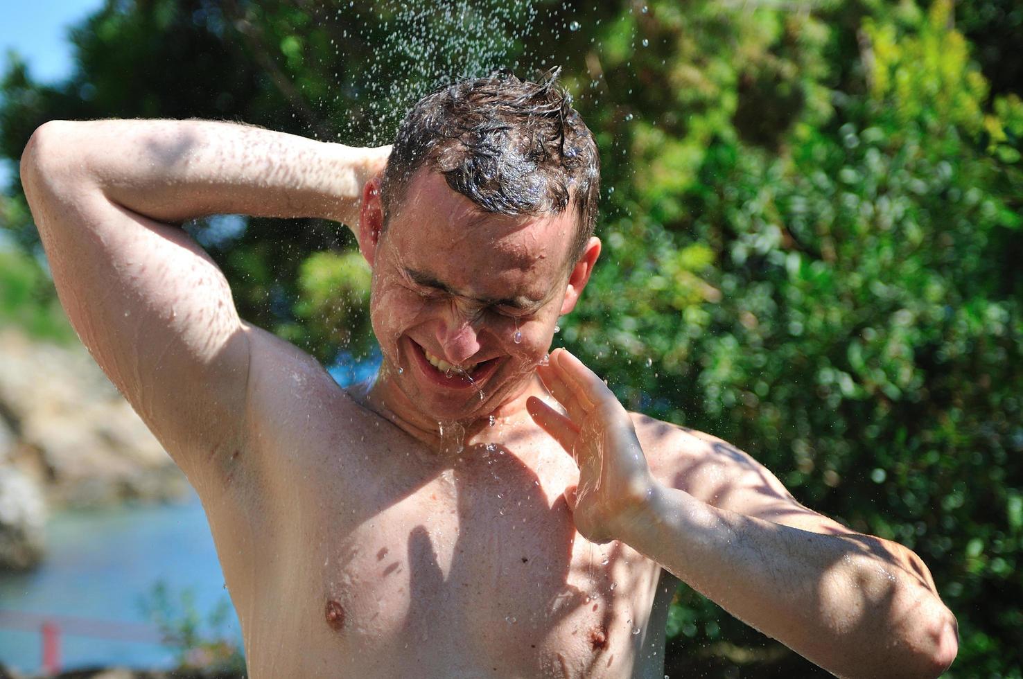 young man relaxing under shower photo