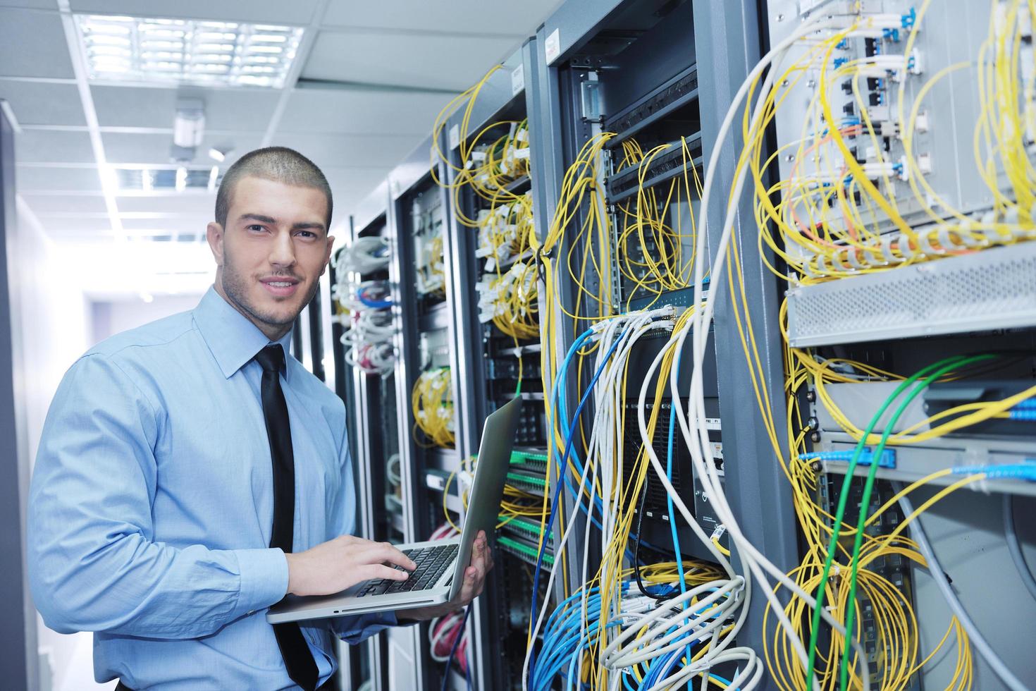 businessman with laptop in network server room photo