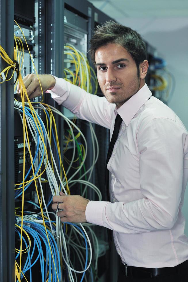 young it engineer in datacenter server room photo