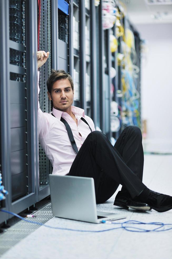 businessman with laptop in network server room photo