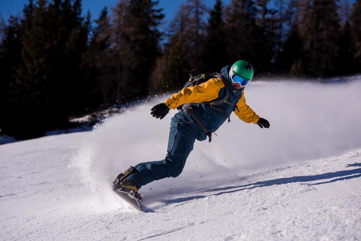 snowboarder running down the slope and ride free style photo