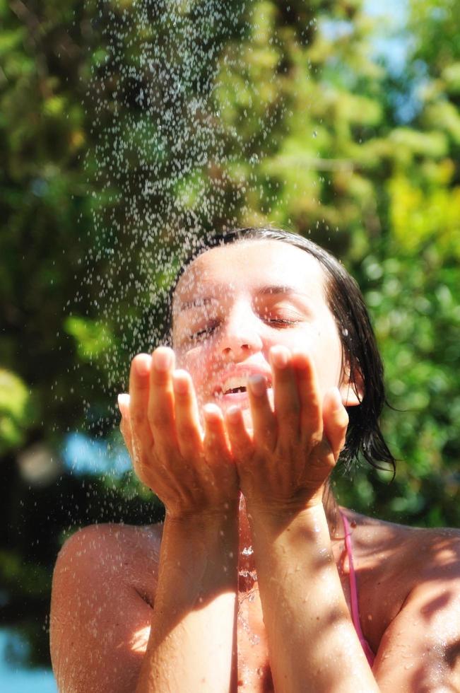 beautiful woman washing and cleaning face under shower photo