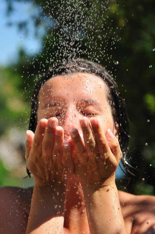 mujer bonita joven que se relaja bajo la ducha foto