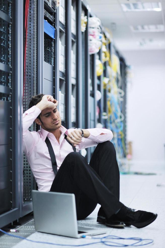 businessman with laptop in network server room photo