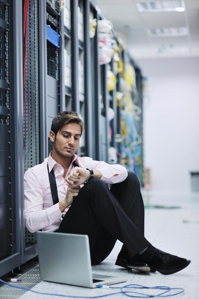 businessman with laptop in network server room photo