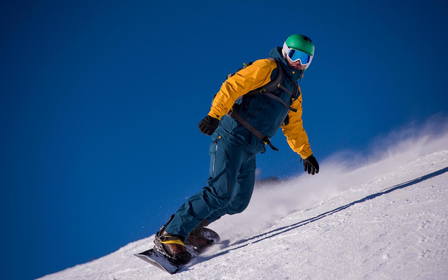 snowboarder corriendo por la pendiente y montando estilo libre foto