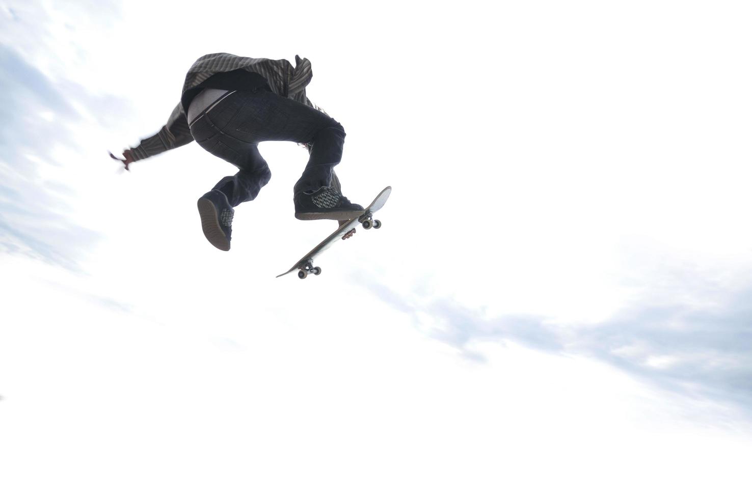 Boy practicing skate in a skate park photo