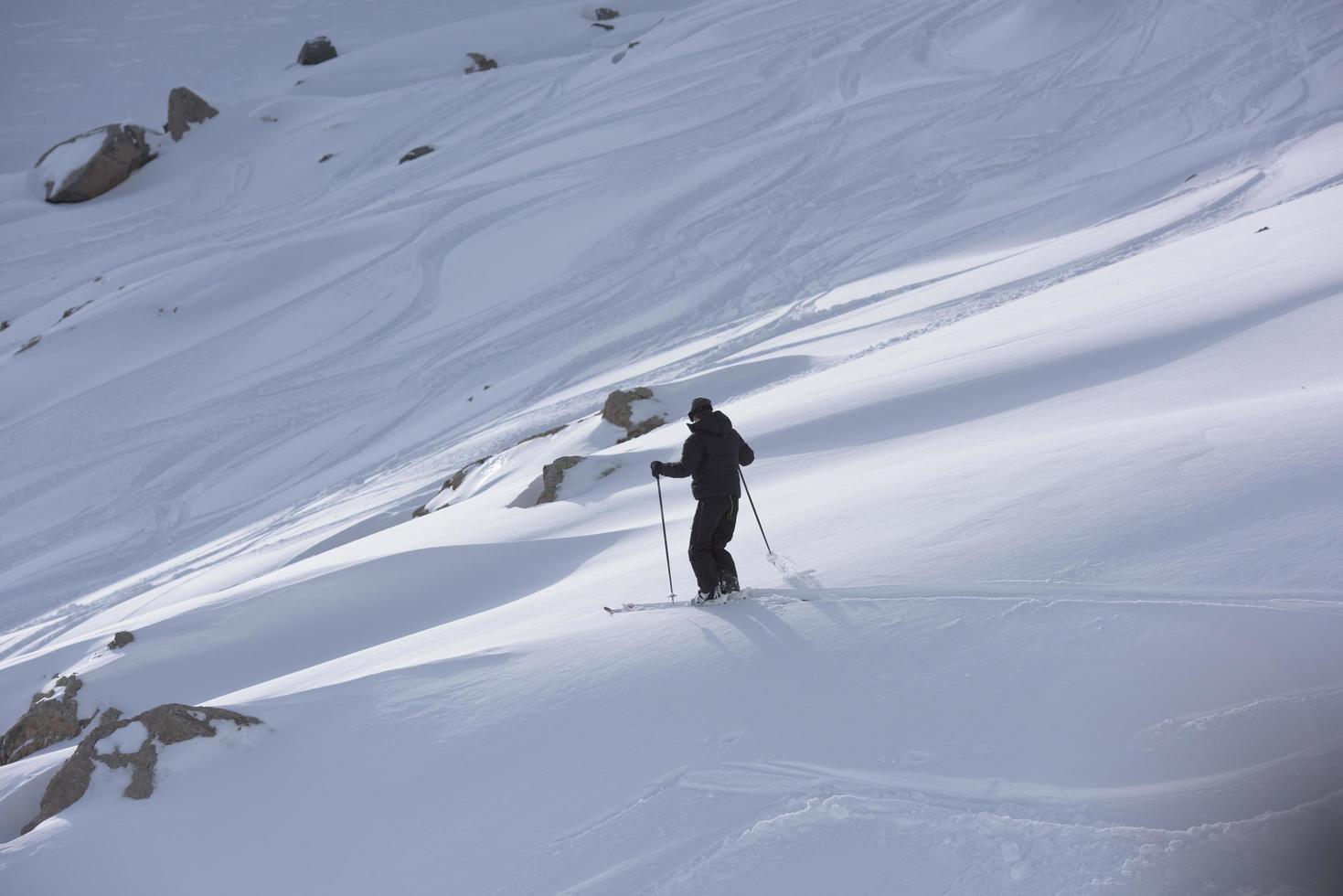 esquiador de freeride esquiando en nieve polvo profunda foto