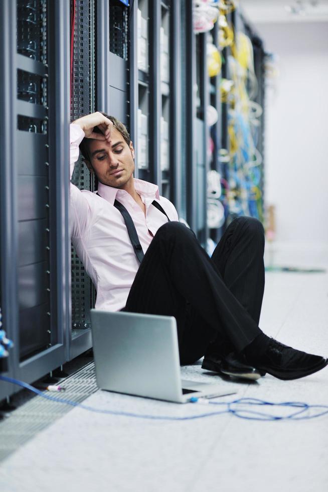 businessman with laptop in network server room photo