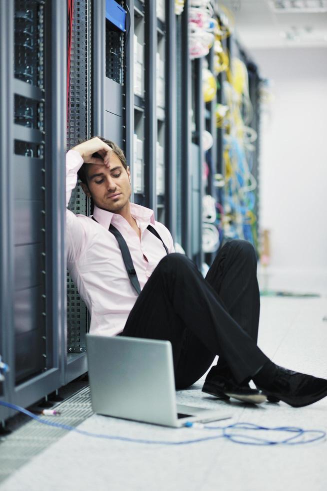 businessman with laptop in network server room photo