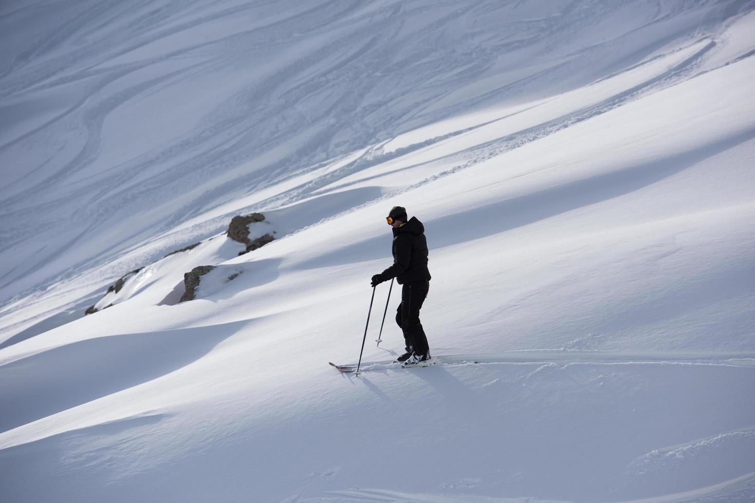 esquiador de freeride esquiando en nieve polvo profunda foto