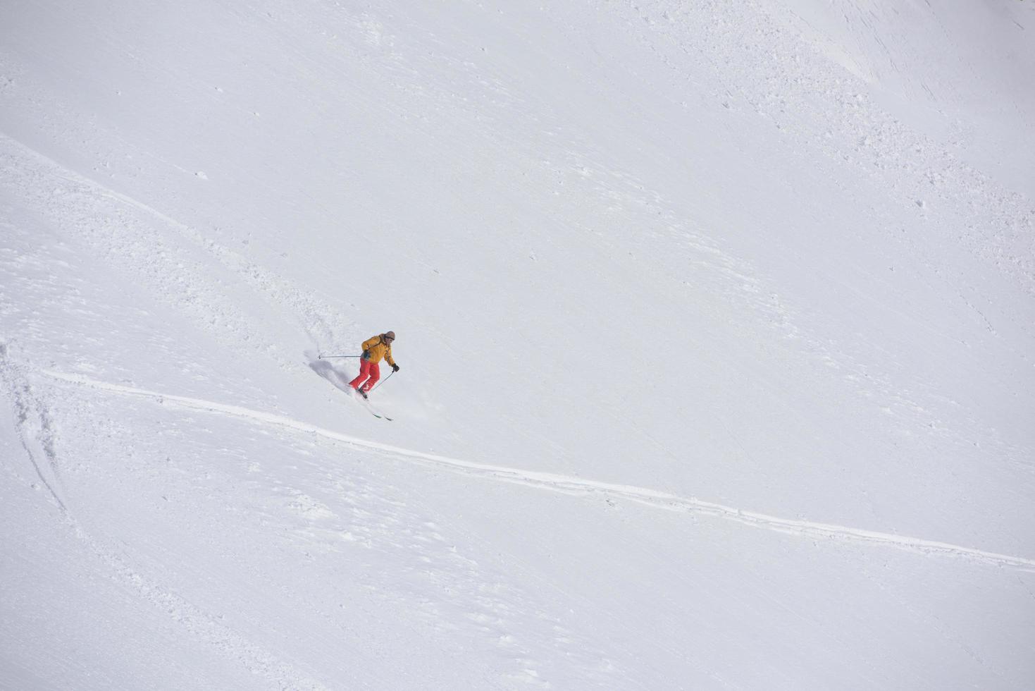 freeride skier skiing in deep powder snow photo