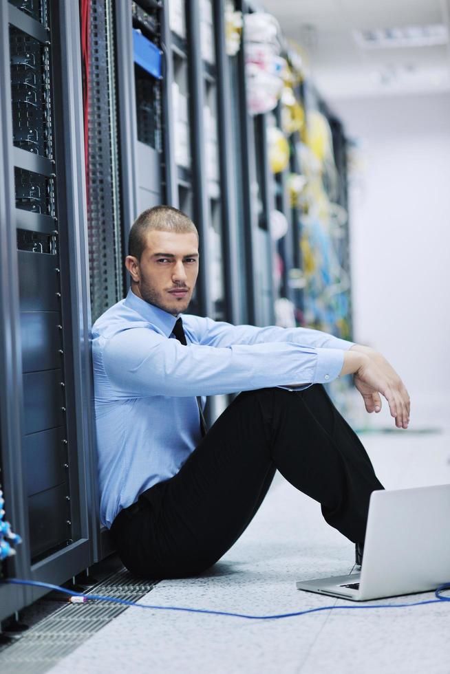 businessman with laptop in network server room photo