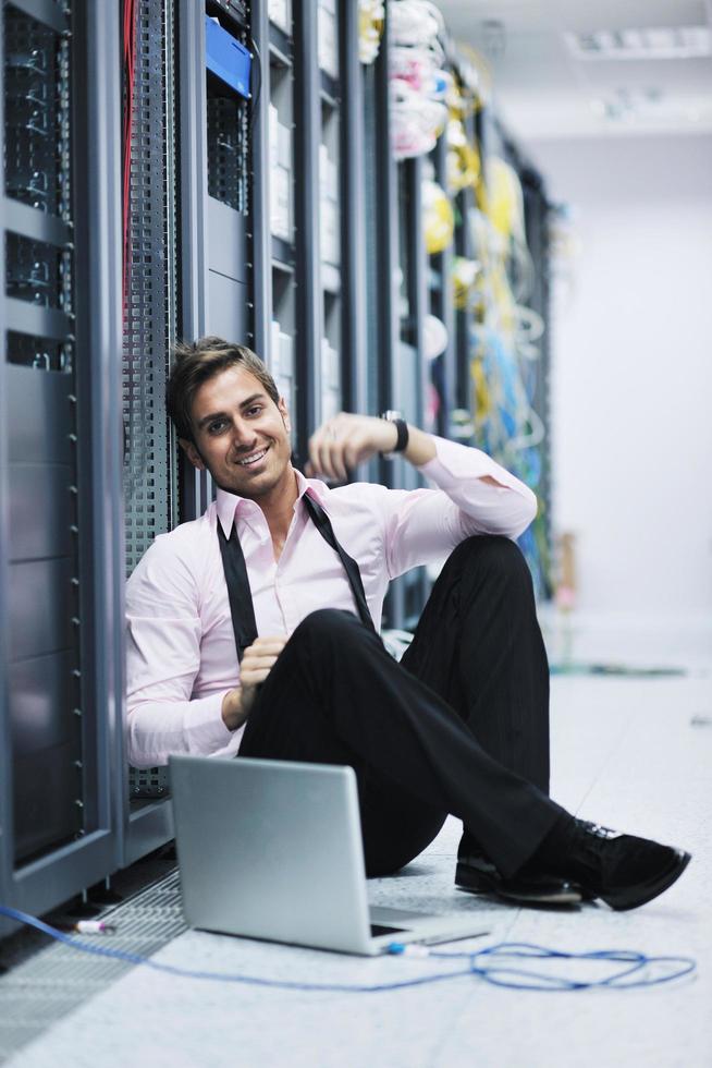 businessman with laptop in network server room photo