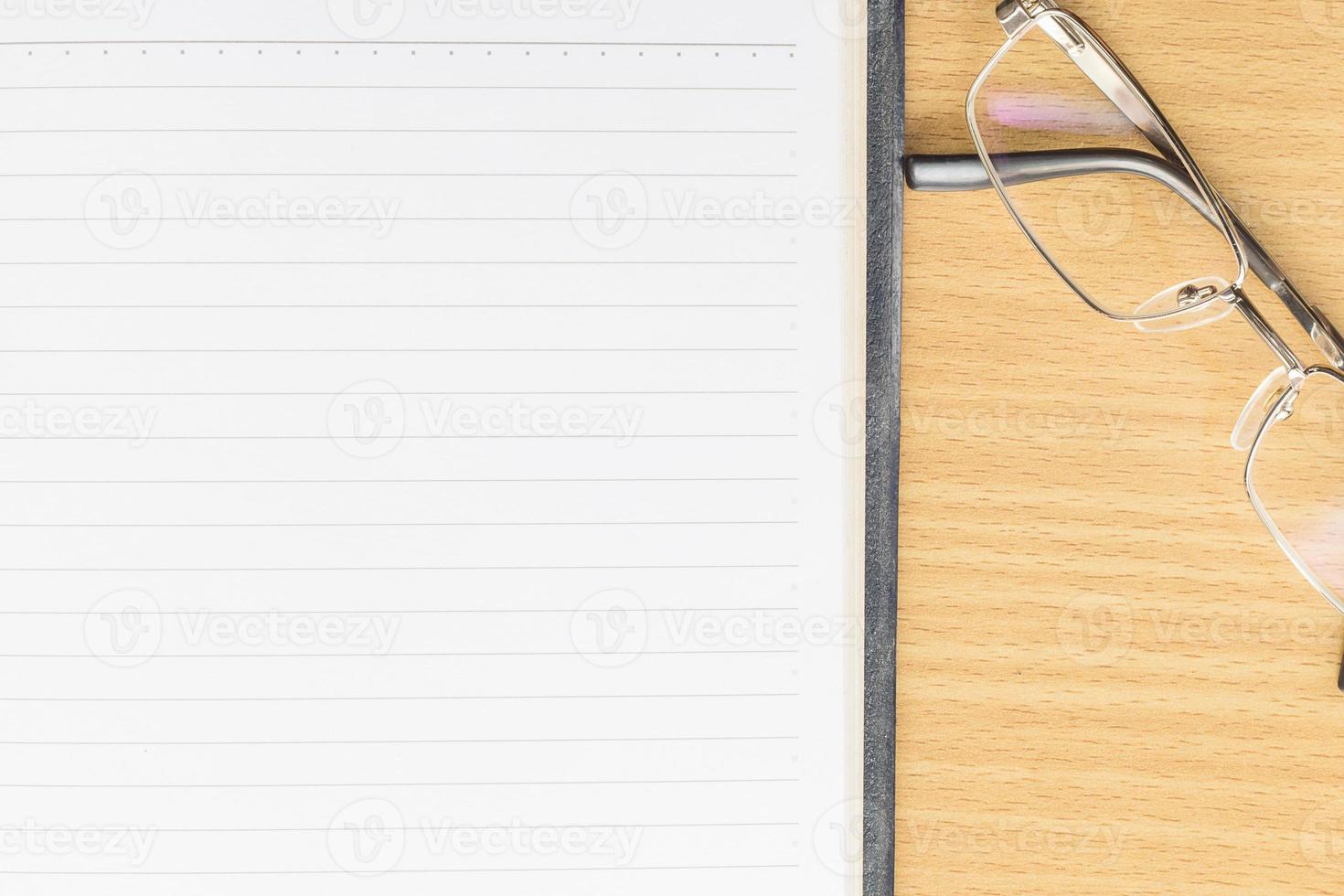 Notebook open blank page and eyeglasses photo