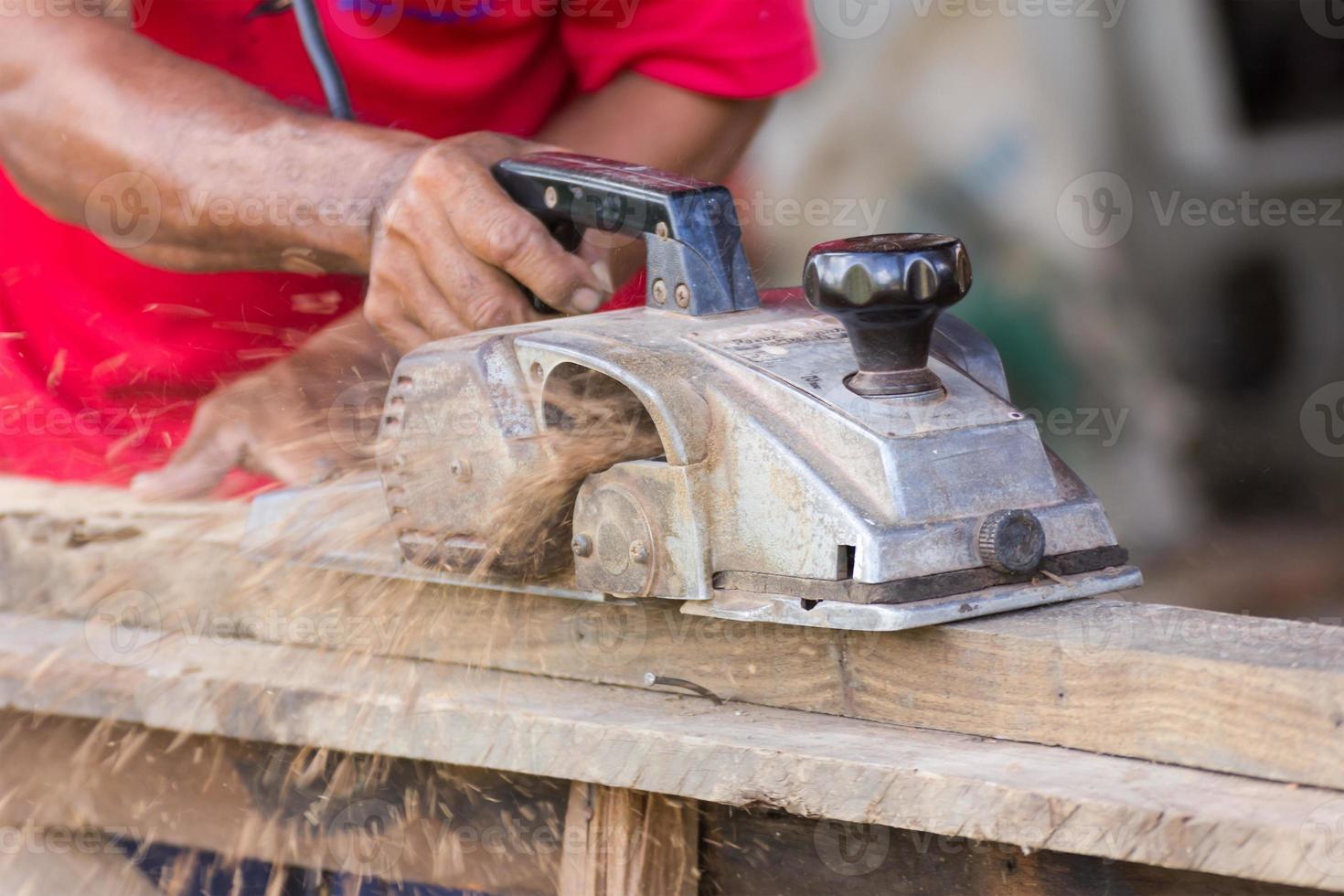 Carpenter working with electric planer photo