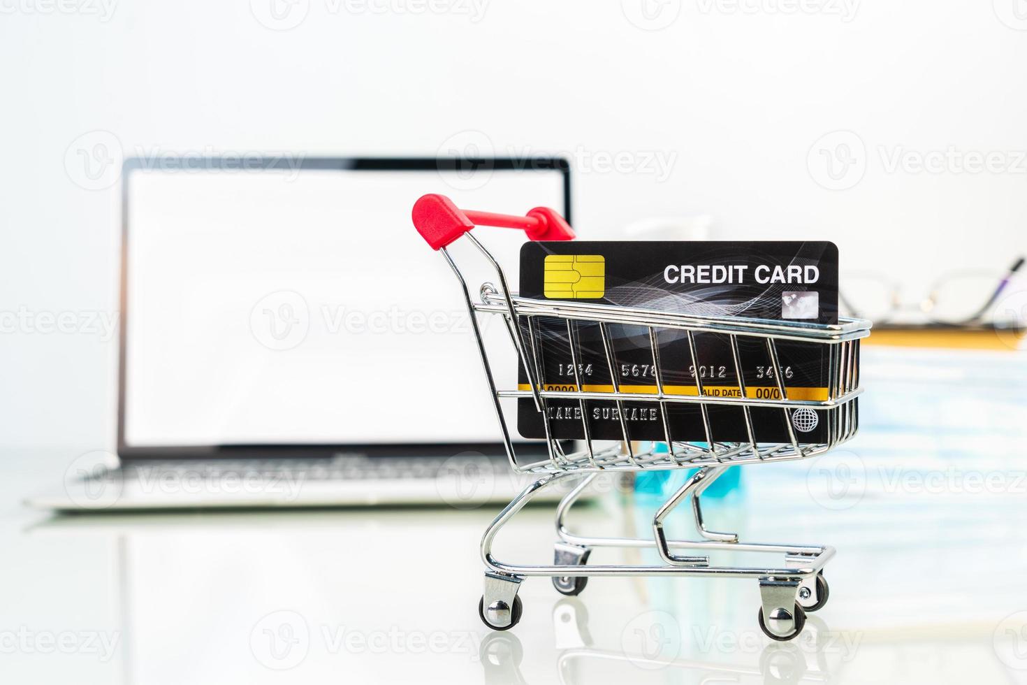 Credit card in shopping cart front of laptop screen with alcohol gel bottle-2 photo