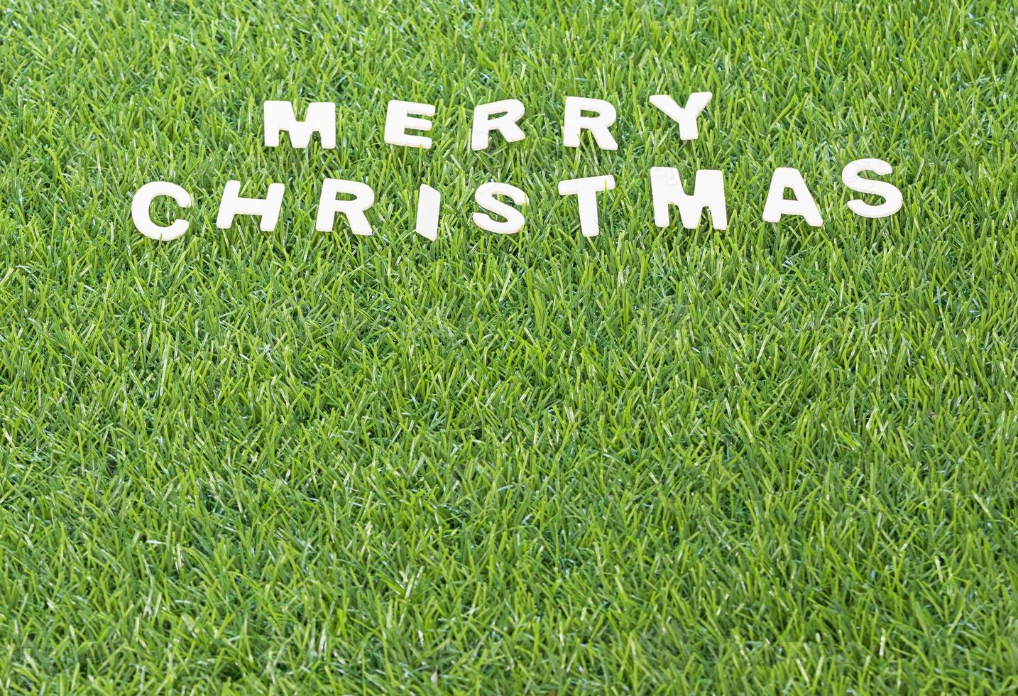 Christmas wood alphabet on green grass photo