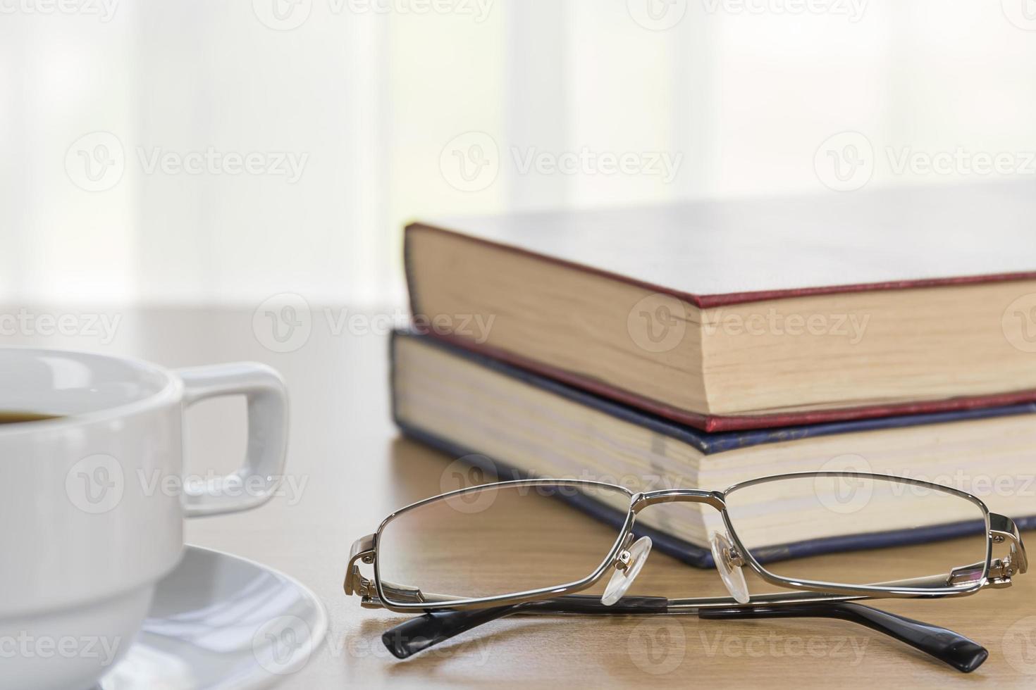 Book and Eyeglasses on a wood table photo