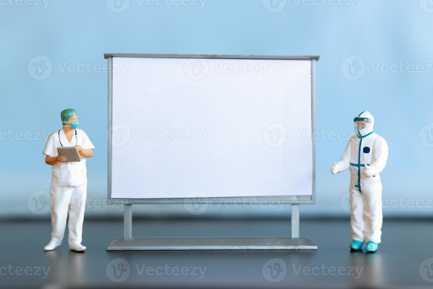 Miniature Doctor standing With Blank White Board photo