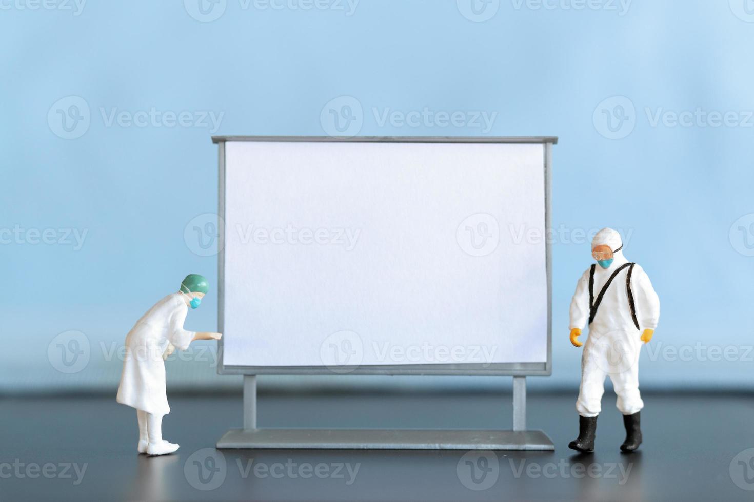 Miniature Doctor standing With Blank White Board photo