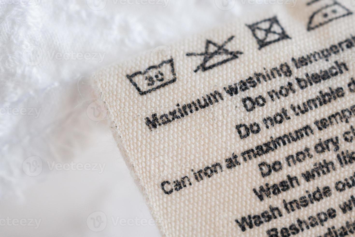 laundry care washing instructions clothes label on fabric texture background photo