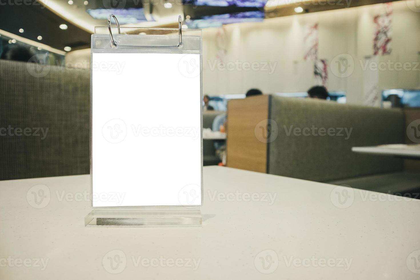 Mockup empty white label menu frame on table with cafe restaurant interior background photo
