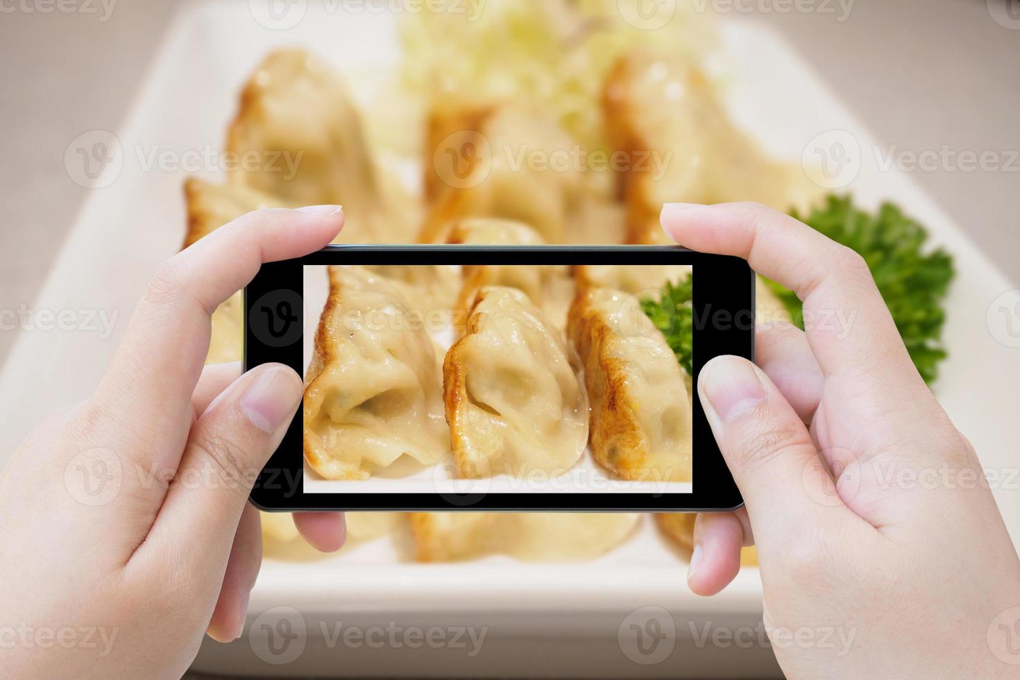 taking photo of Gyoza dumplings with smartphone