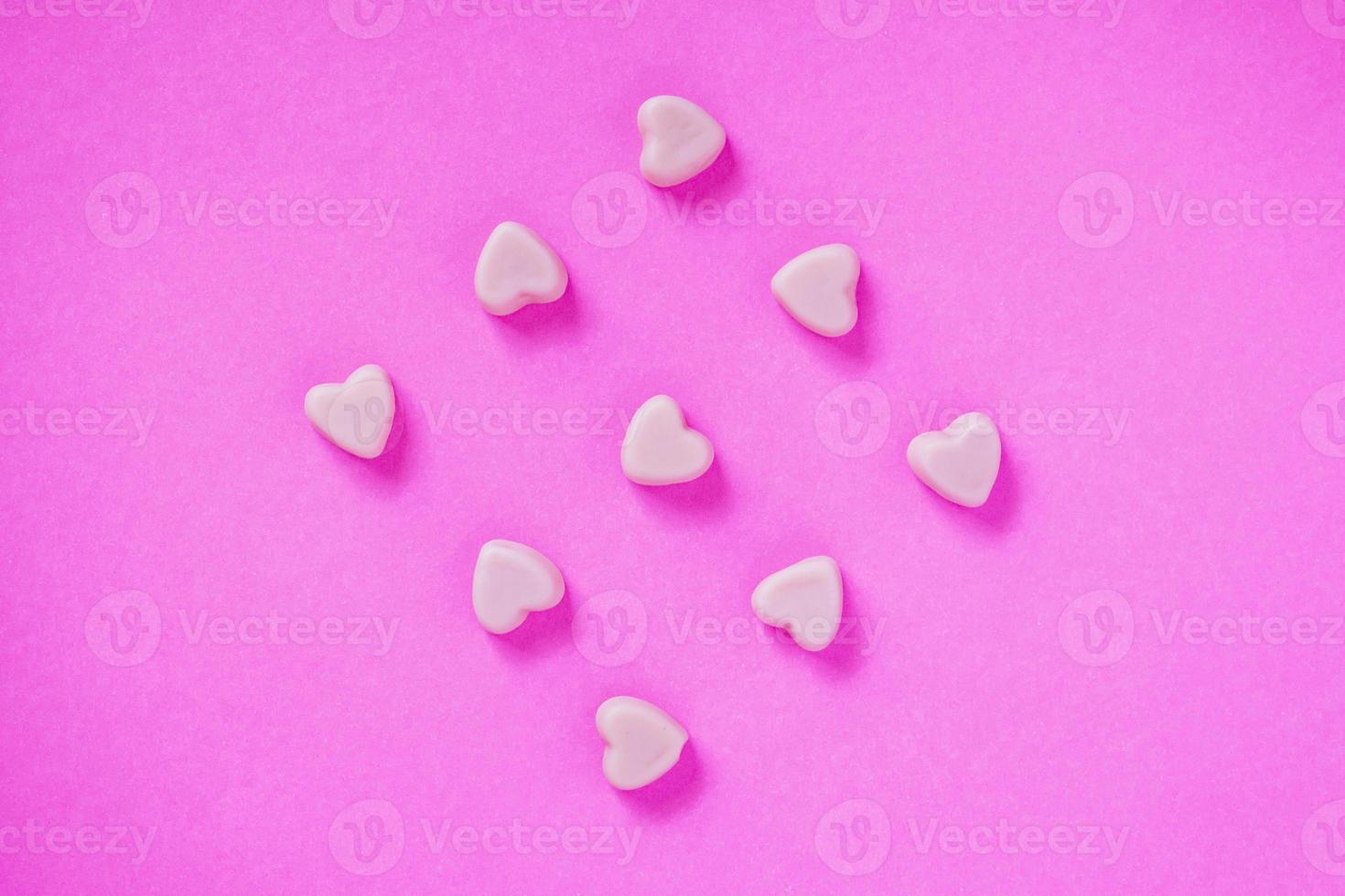 valentine candy hearts shape on pink background photo