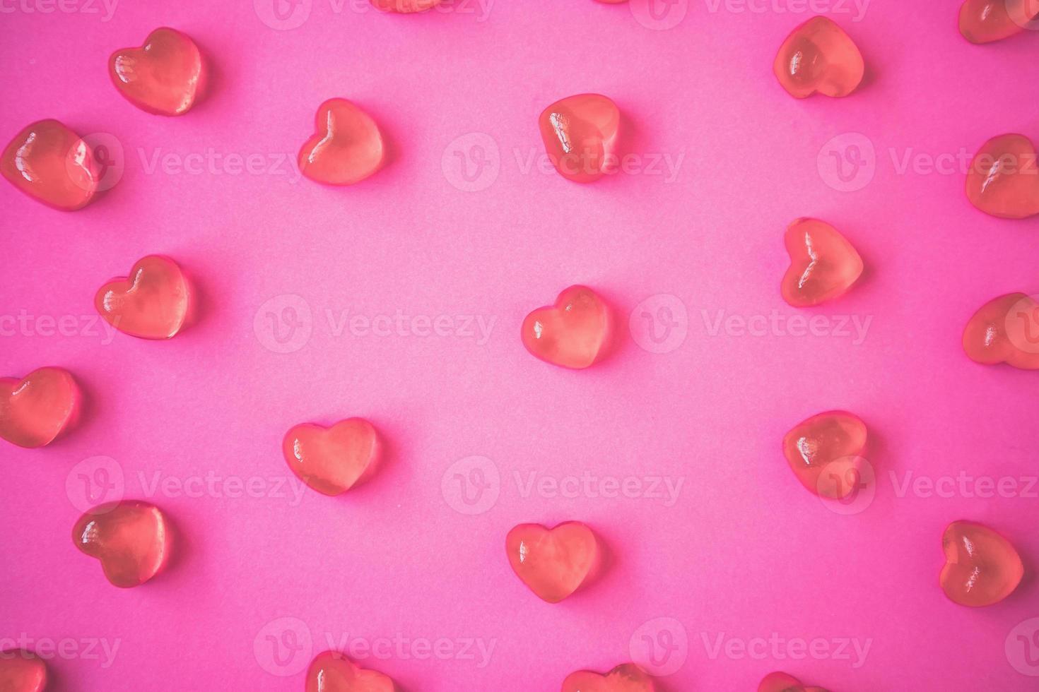 Valentines day background with heart shape candy on pink background photo