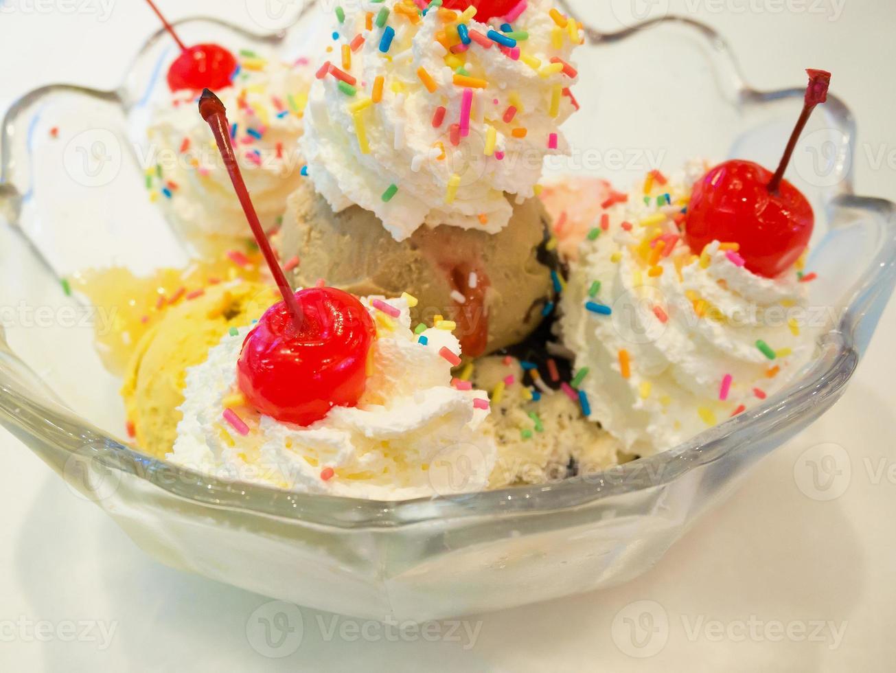 Ice cream scoops with whipped cream and cherry photo