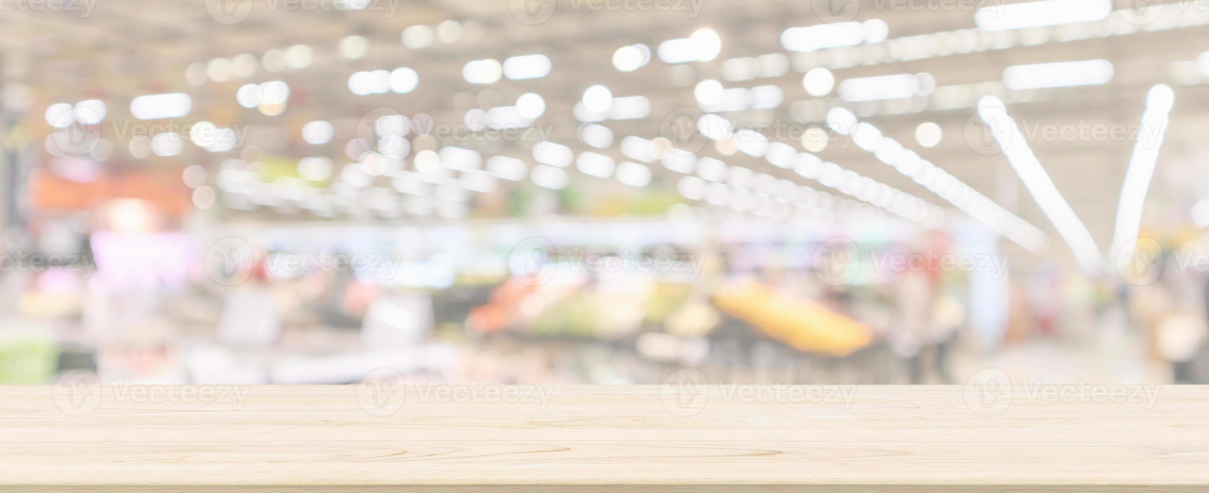Wood table top with supermarket grocery store blurred defocused panorama background with bokeh light for product display photo