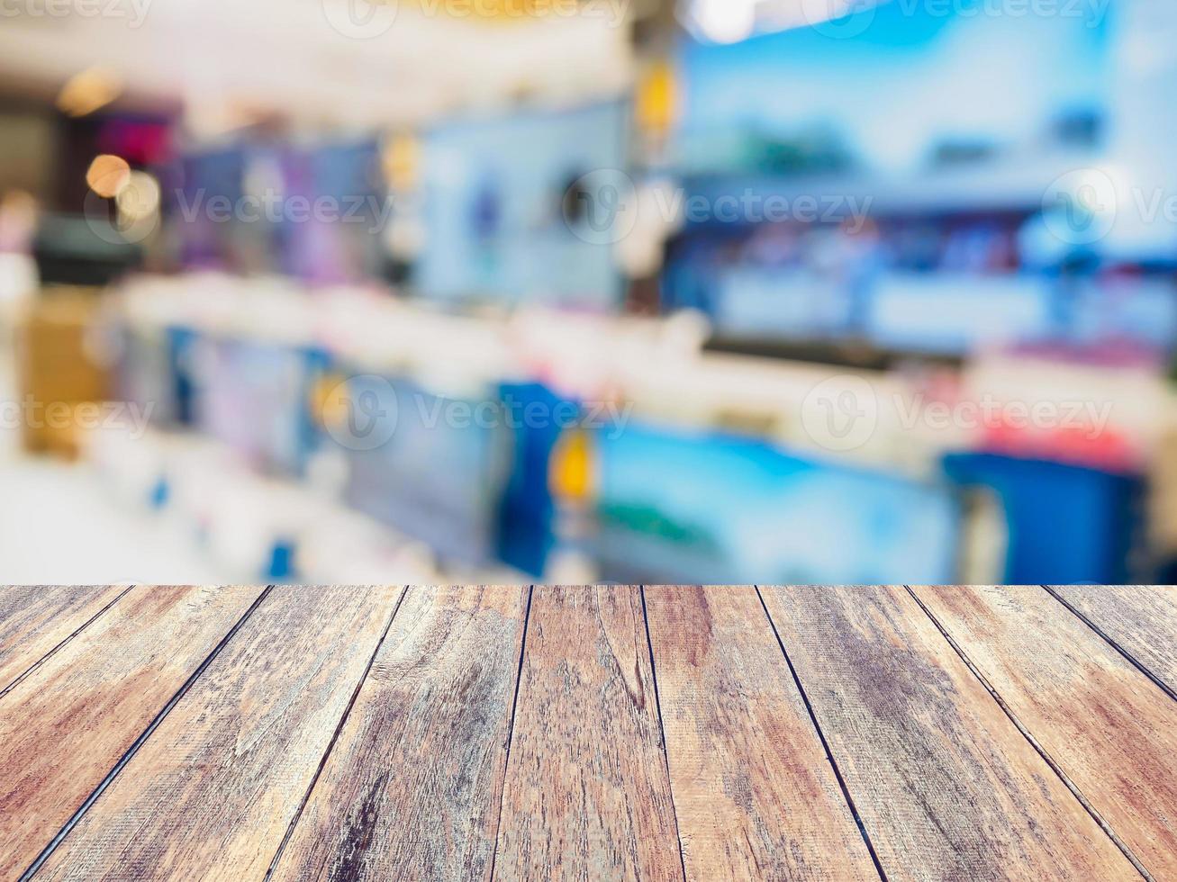 Wood table over Television shelf in eletronic store blurred background photo