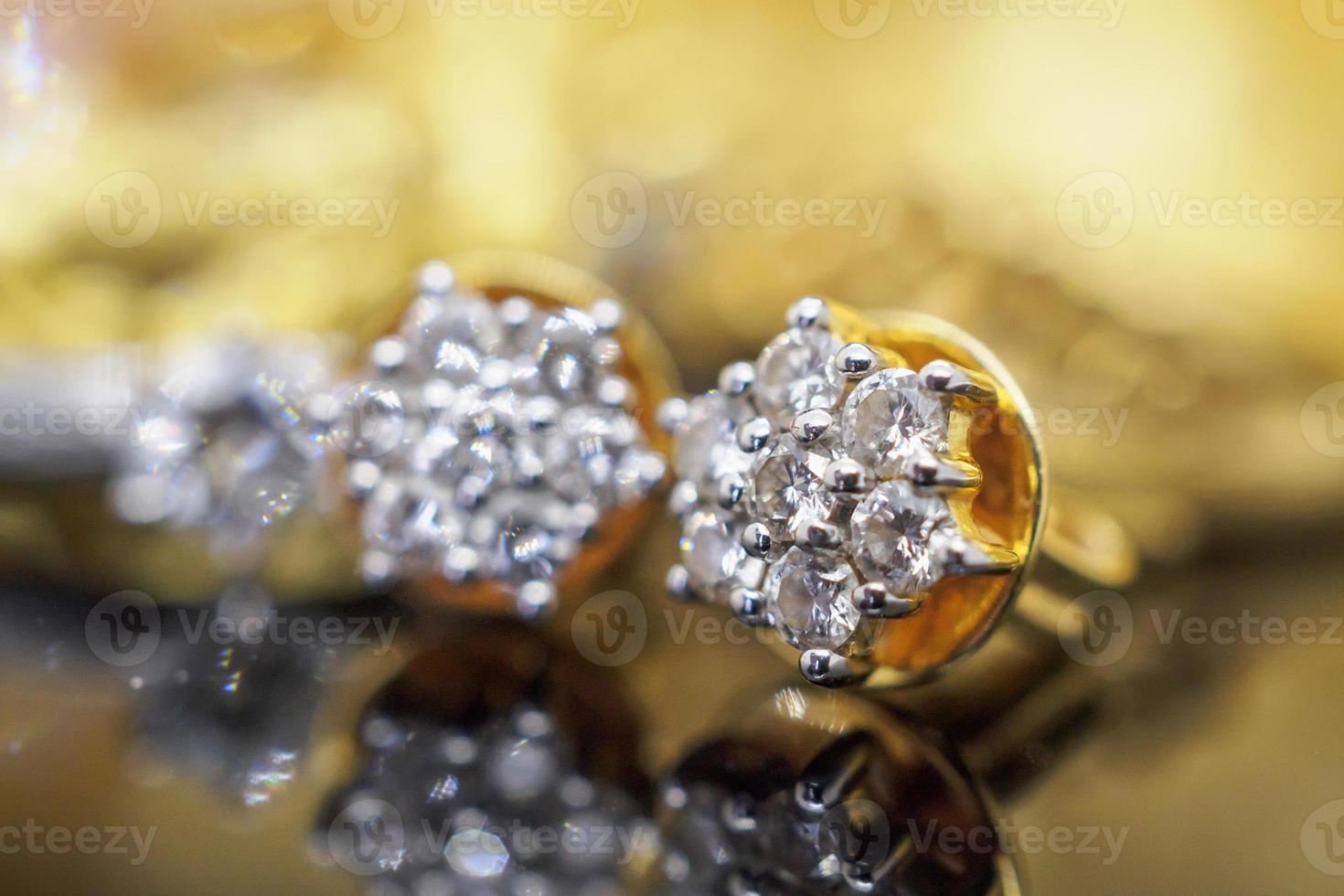 Luxury gold Jewelry diamond earrings with reflection on black background photo
