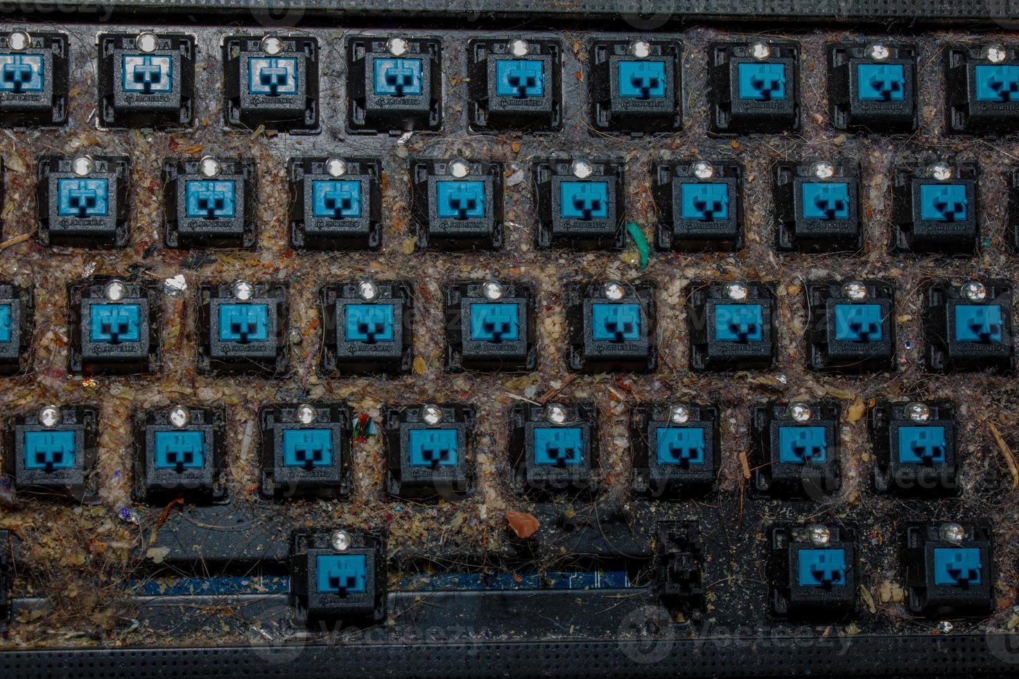 Very dirty keyboard. Dog hair, breadcrumbs and dust accumulated under the keys. Mechanical keyboard switches without buttons photo