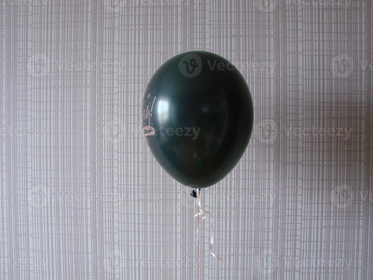 Black balloon with words HAPPY BIRTHDAY on yellow background, space for text photo