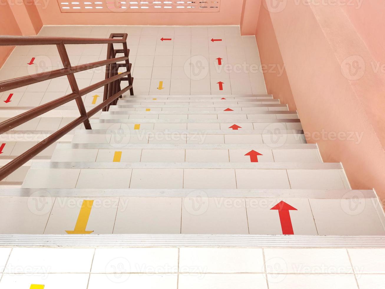 The stairs go up and down the building with red yellow arrows for safety and order. photo
