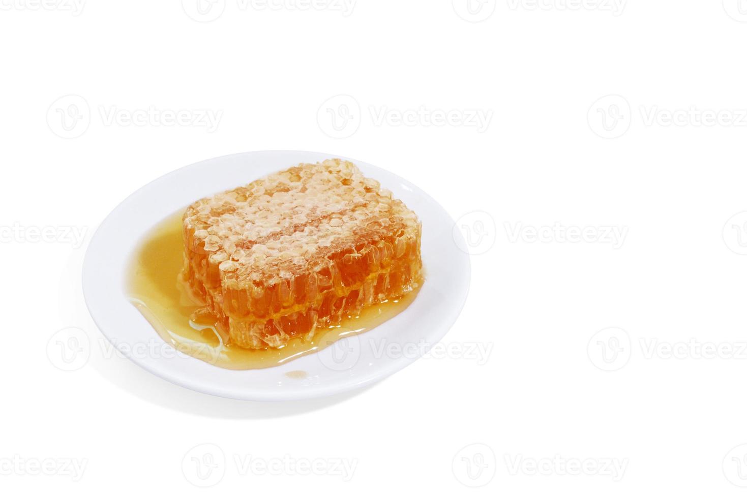 beeswax honeycomb yellow natural honey slices on white plate isolated on white background photo
