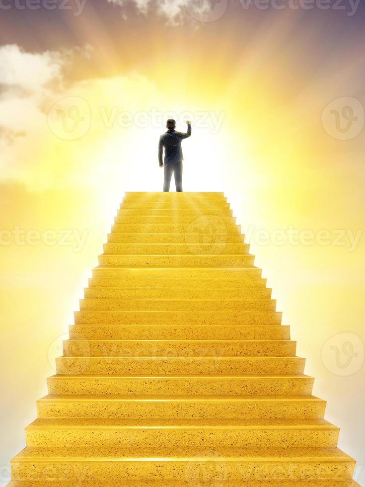 businessman on golden concrete stairs leading to light hope success concept photo