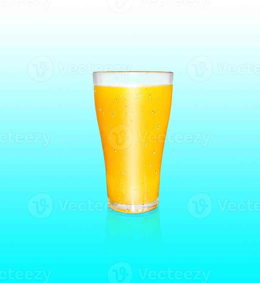 A glass of orange juice contains orange pulp. with the reflection of a glass of orange juice on a blue background photo