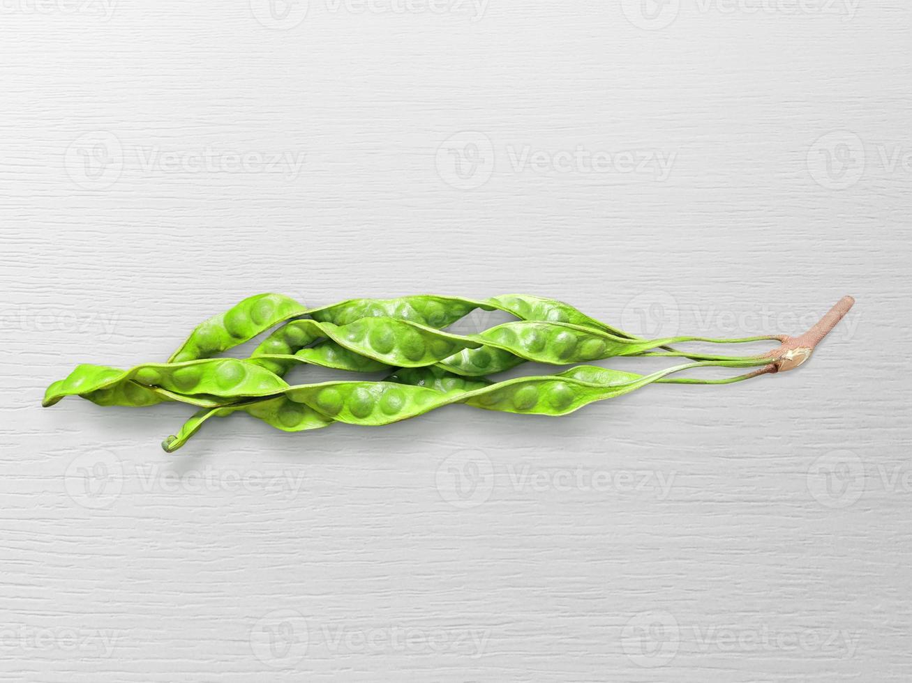 Petai or bitter beans or stinky beans on white wooden table background photo