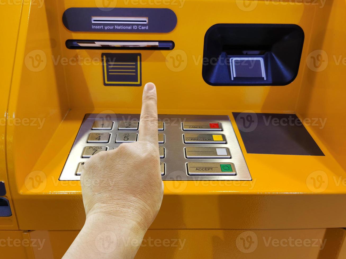 la mano de un hombre está a punto de ingresar un código en el teclado numérico de un cajero automático foto