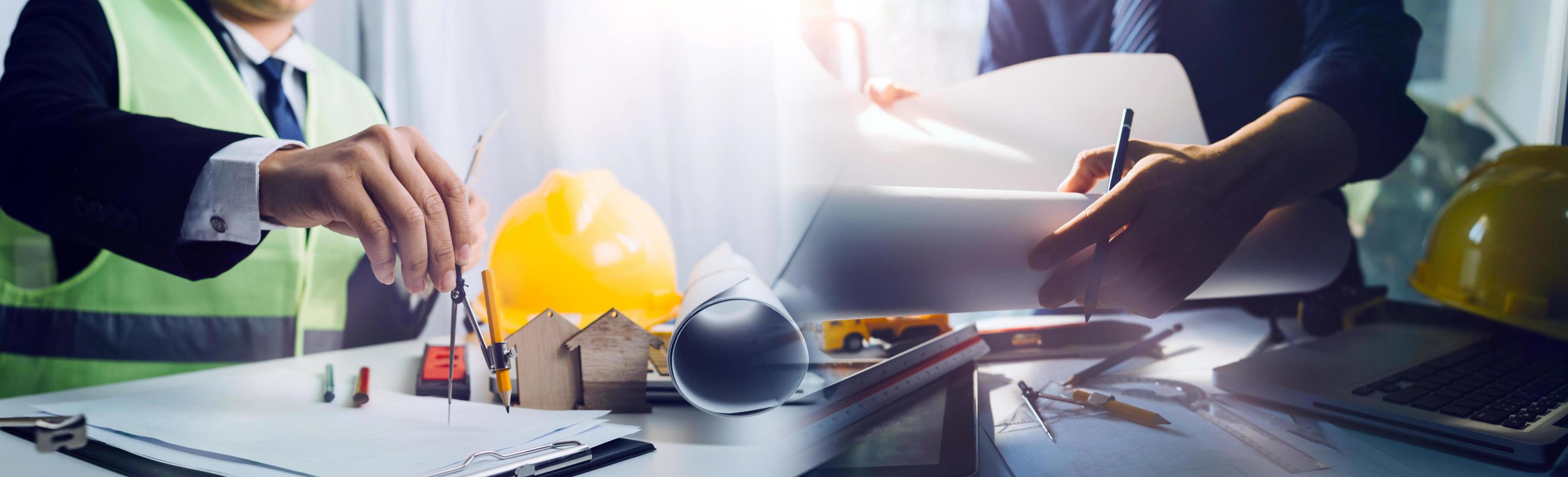 business hand working and laptop with on on architectural project at construction site at office desk in office photo