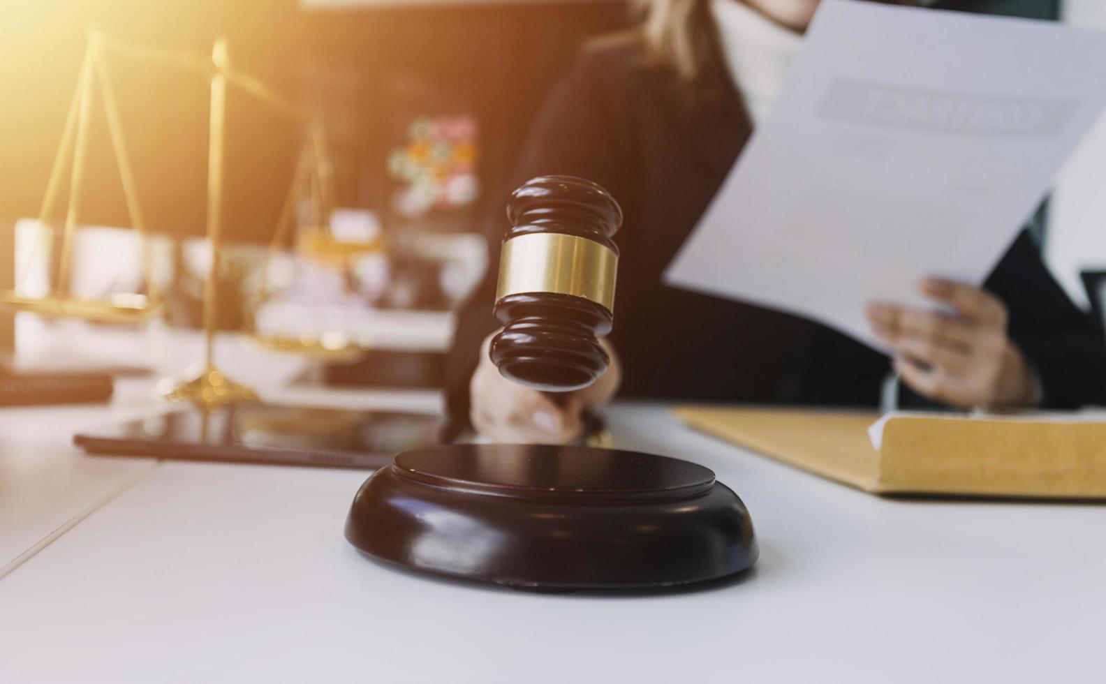 Male lawyer working with contract papers and wooden gavel on tabel in courtroom. justice and law ,attorney, court judge, concept. photo